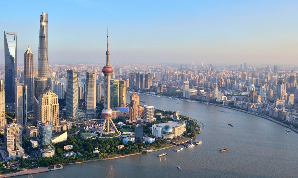 Aerial view of the Shanghai skyline featuring the Oriental Pearl Tower, Shanghai Tower, and Huangpu River, showcasing the city’s modern architecture and financial district.