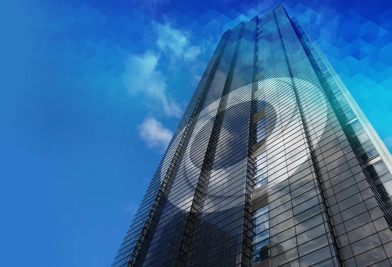 Glass skyscraper with a stylized circular logo reflected across its facade, viewed from below against a bright blue sky with clouds.