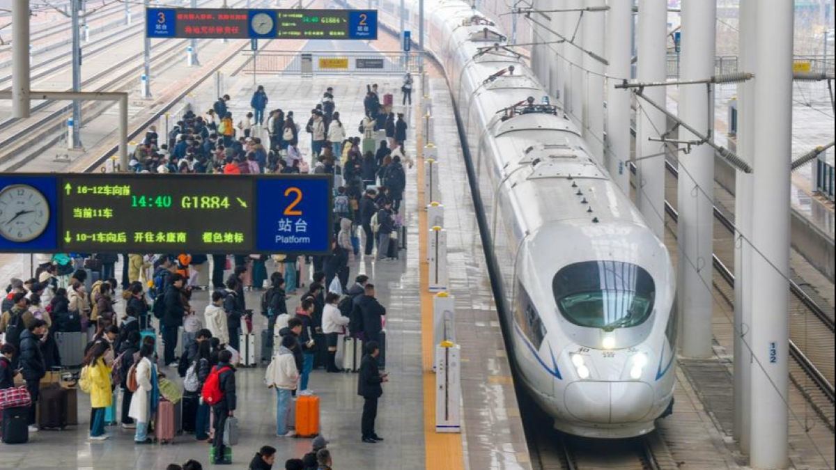 Passengers waiting at a busy Chinese high-speed railway station as a CRH bullet train prepares for departure.