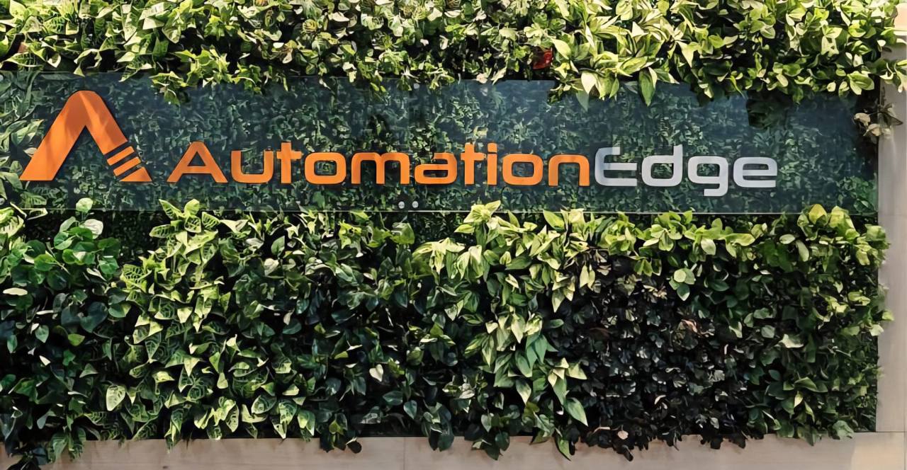 AutomationEdge company logo displayed on a green vertical plant wall inside the corporate office, highlighting the brand’s identity and eco-friendly workplace design