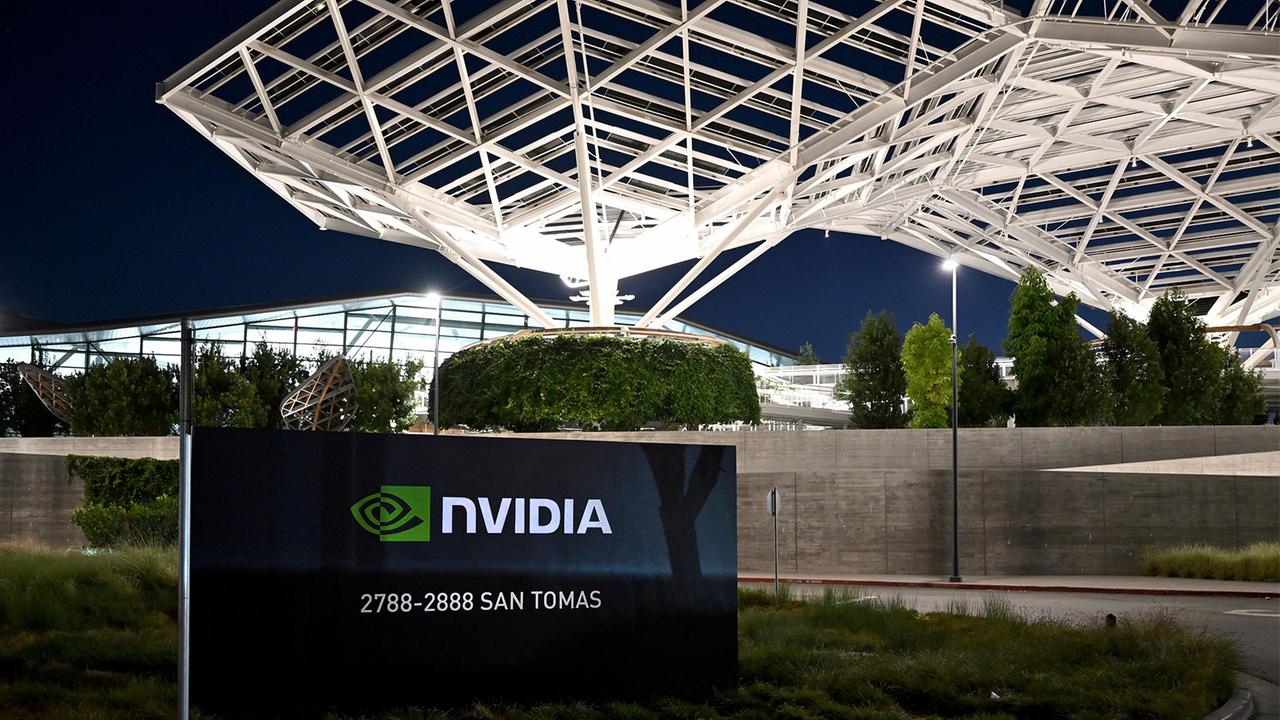 Alt text: “NVIDIA headquarters sign at 2788–2888 San Tomas, with a modern glass campus and illuminated lattice roof structure at night.