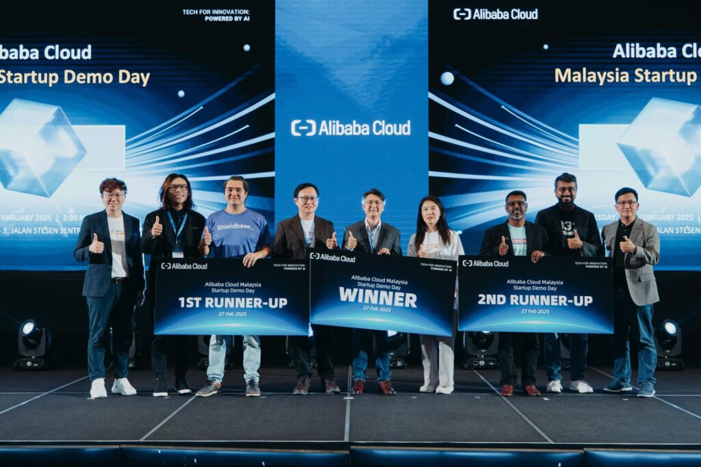 Winners and finalists pose on stage at the Alibaba Cloud Malaysia Startup Demo Day, holding winner and runner-up boards, highlighting AI-powered innovation, cloud technology adoption, and Malaysia’s growing startup ecosystem.