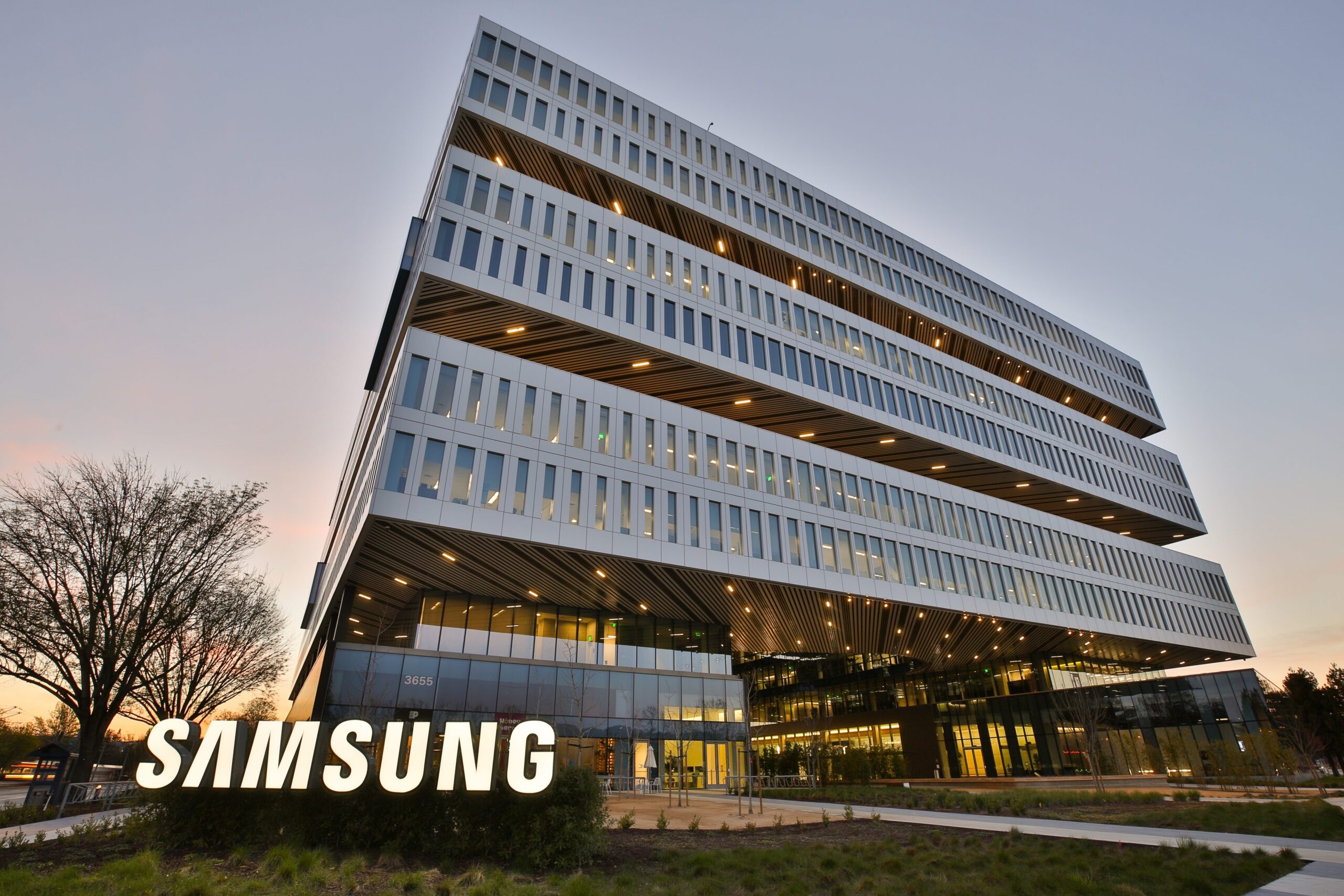 Samsung corporate office building with modern stacked architecture and illuminated Samsung logo at dusk, showcasing the company’s global technology headquarters.