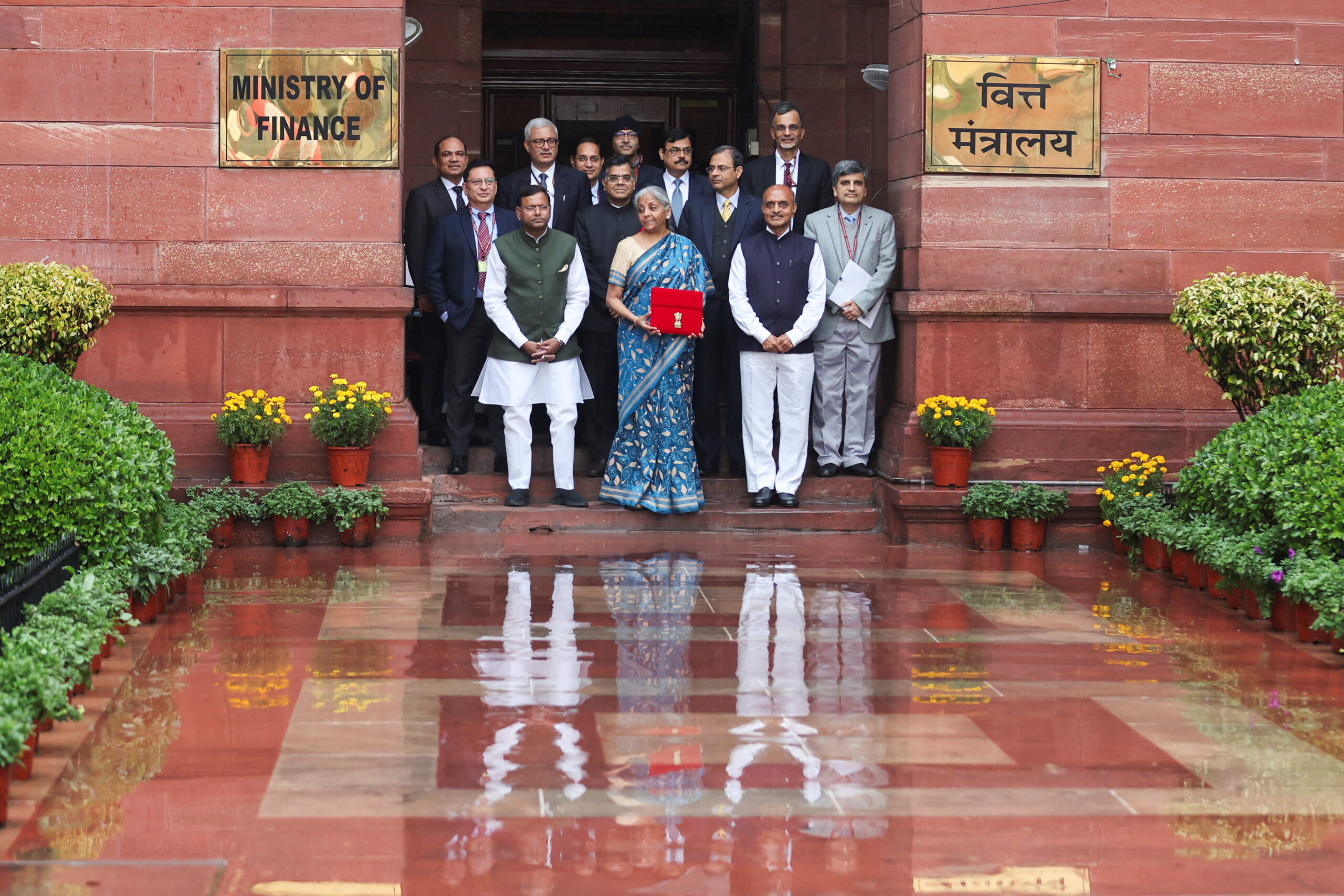 Indian finance minister Nirmala Sitharaman stands with senior government officials outside the Ministry of Finance in New Delhi, holding the red budget document ahead of India’s Union Budget announcement.
