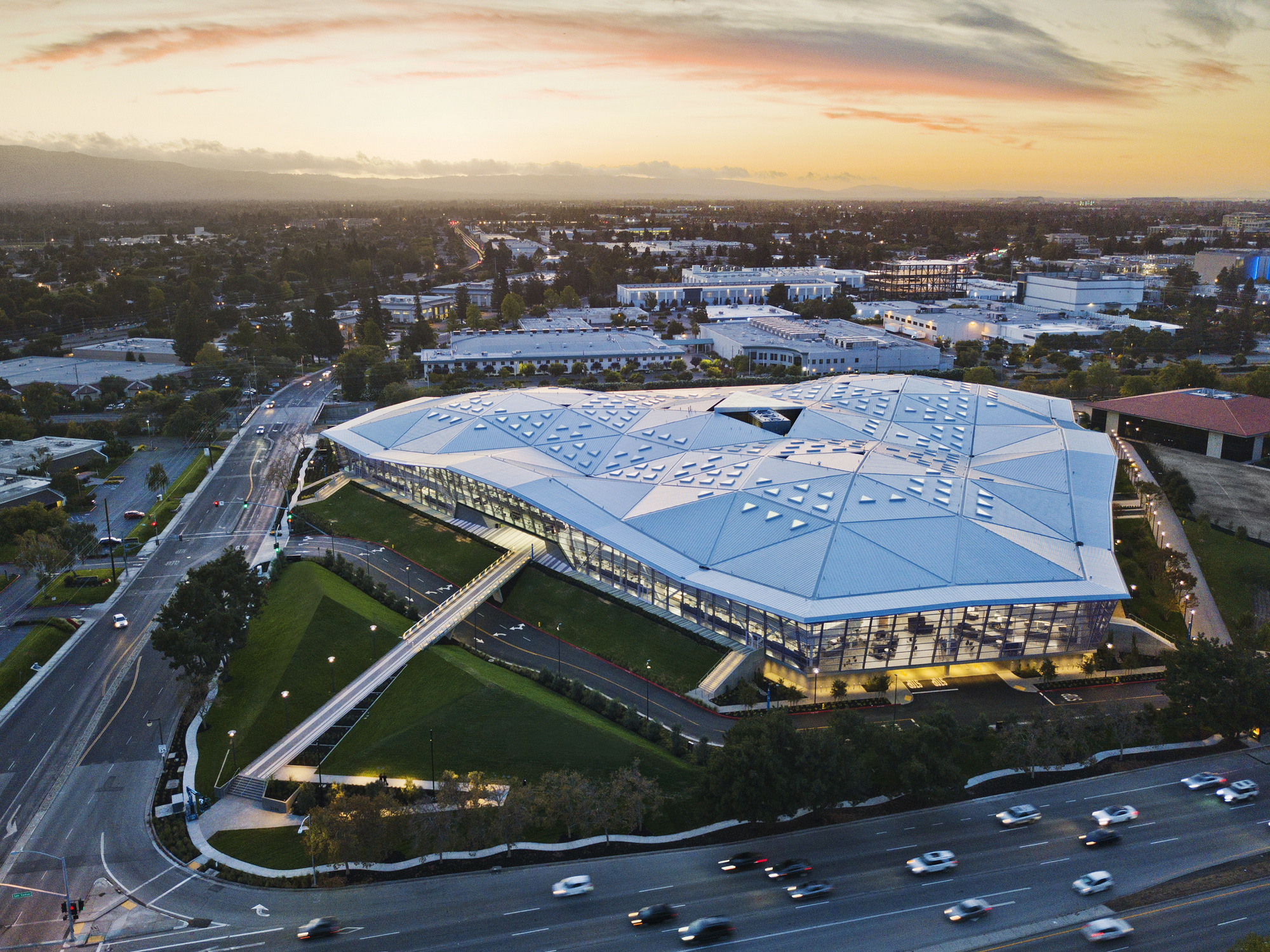 Aerial view of Apple Park’s Steve Jobs Theater campus in Cupertino, showcasing the iconic modern architecture and surrounding technology hub at sunset.