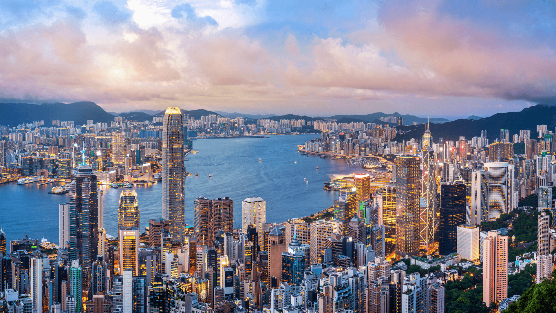 Panoramic view of Hong Kong’s skyline and Victoria Harbour at dusk, showcasing the city’s iconic skyscrapers, financial district, and status as a global business and financial hub in Asia.