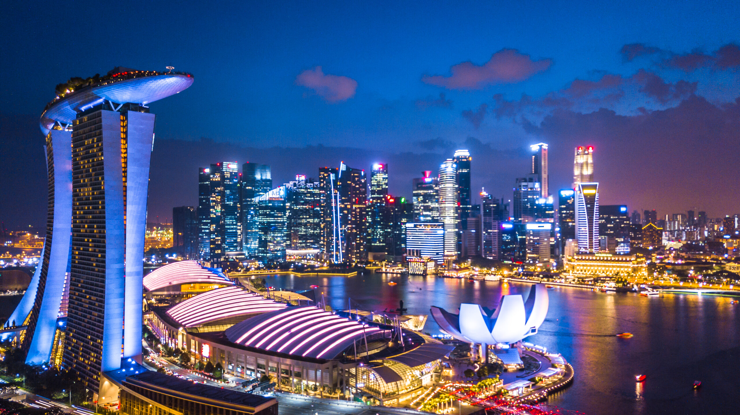 Singapore Marina Bay skyline at night featuring Marina Bay Sands, the ArtScience Museum, and illuminated waterfront