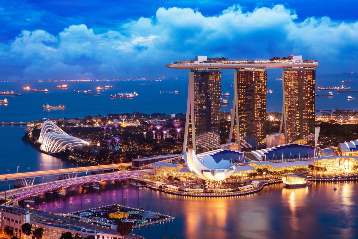Marina Bay Sands skyline at night in Singapore, featuring the SkyPark rooftop, Gardens by the Bay, and illuminated waterfront cityscape along Marina Bay.