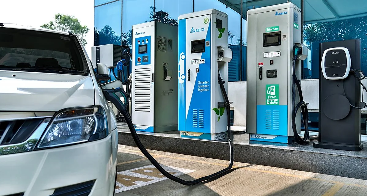 Electric vehicle charging station with multiple fast chargers installed outside a commercial building, showing an EV plugged in and branded charging units, highlighting Asia’s expanding EV infrastructure and clean energy transition.