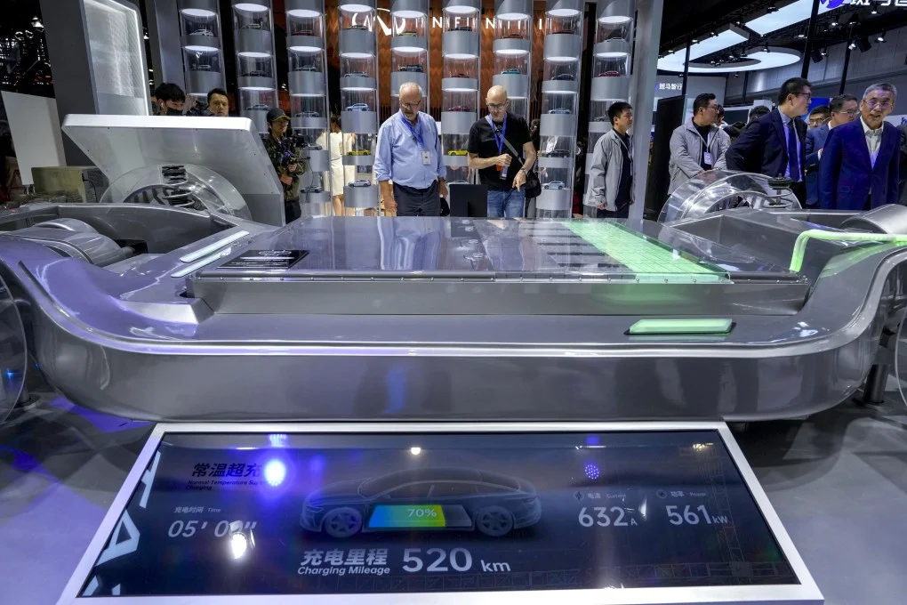 Electric vehicle battery platform showcased at auto technology expo, highlighting fast-charging system with 520 km range and high-power output display.
