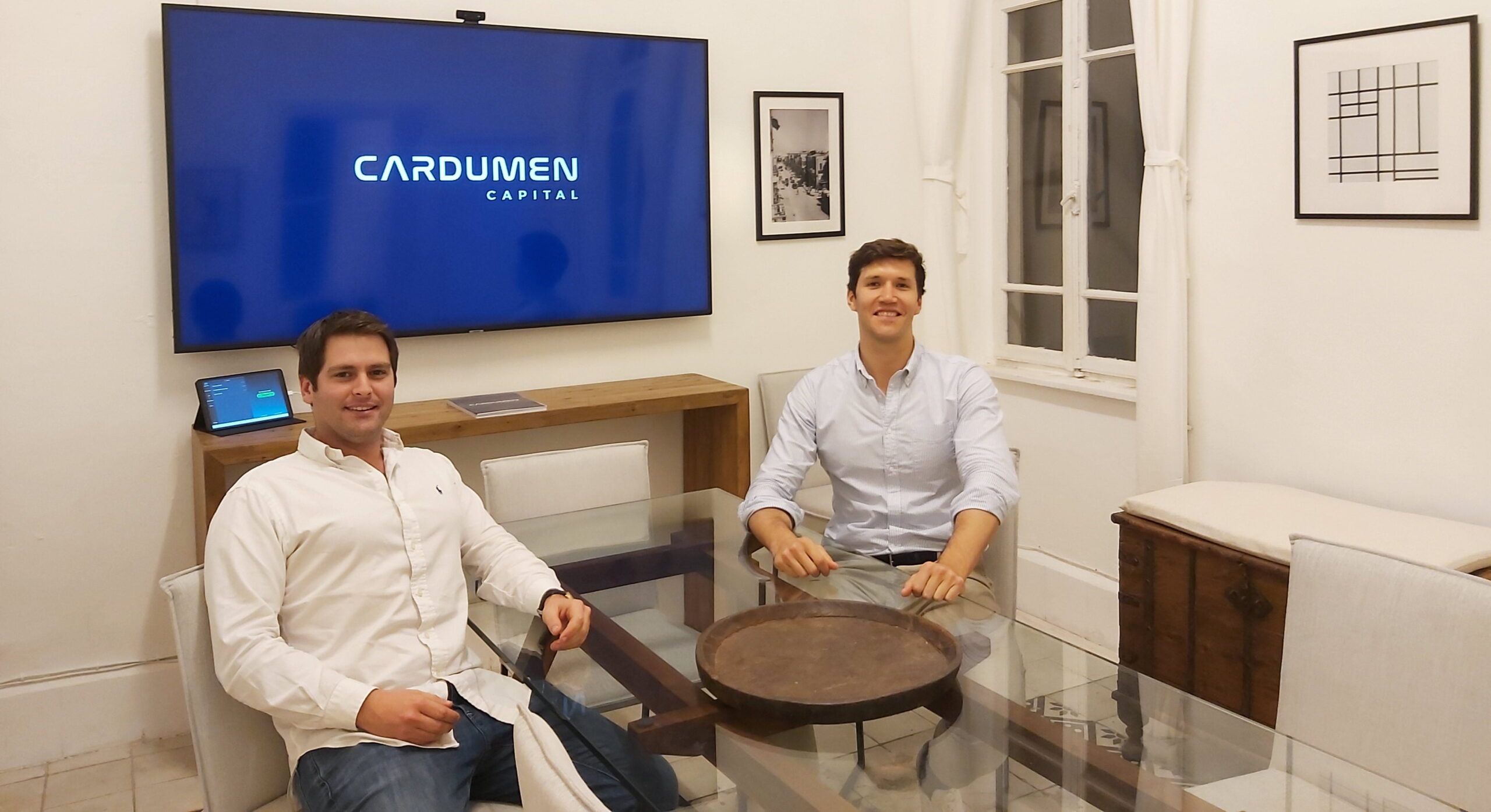 Cardumen Capital founders seated in a modern meeting room with the firm’s logo displayed on a screen, representing the venture capital company’s leadership and investment strategy.