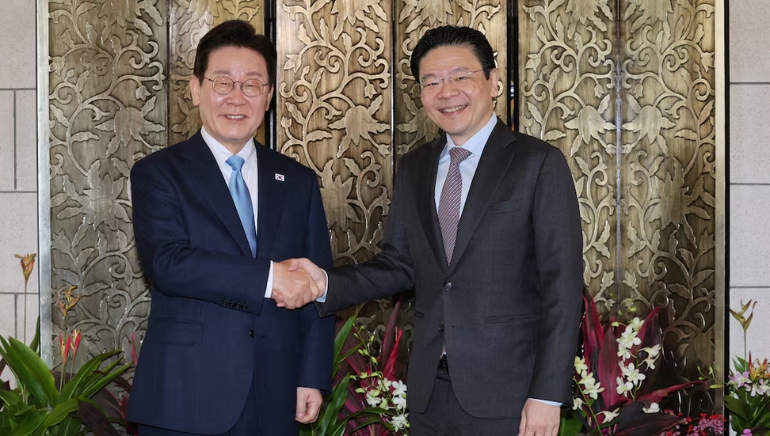 South Korean officials shake hands during diplomatic meeting, symbolizing bilateral cooperation and strategic partnership discussions between government leaders.
