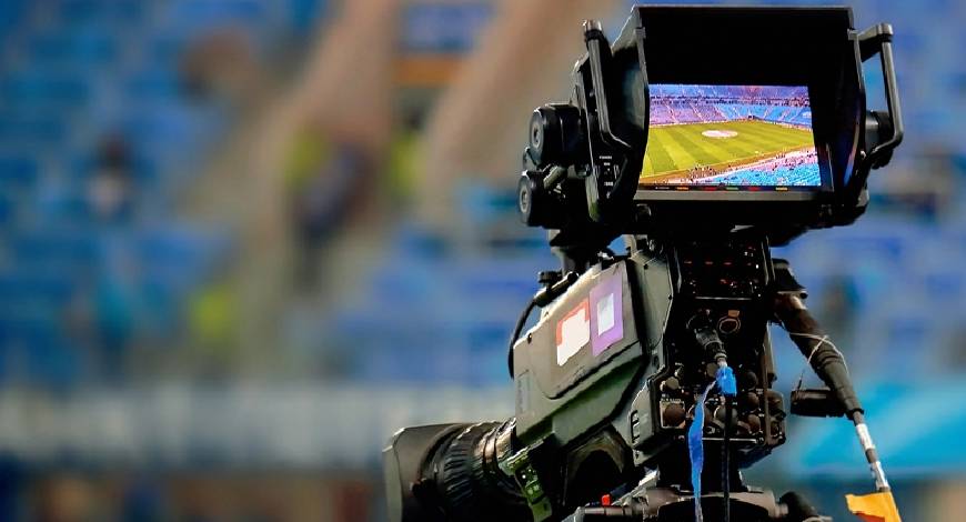 Broadcast camera filming live sports event in stadium, representing sports media production, live streaming technology, and global broadcasting industry.