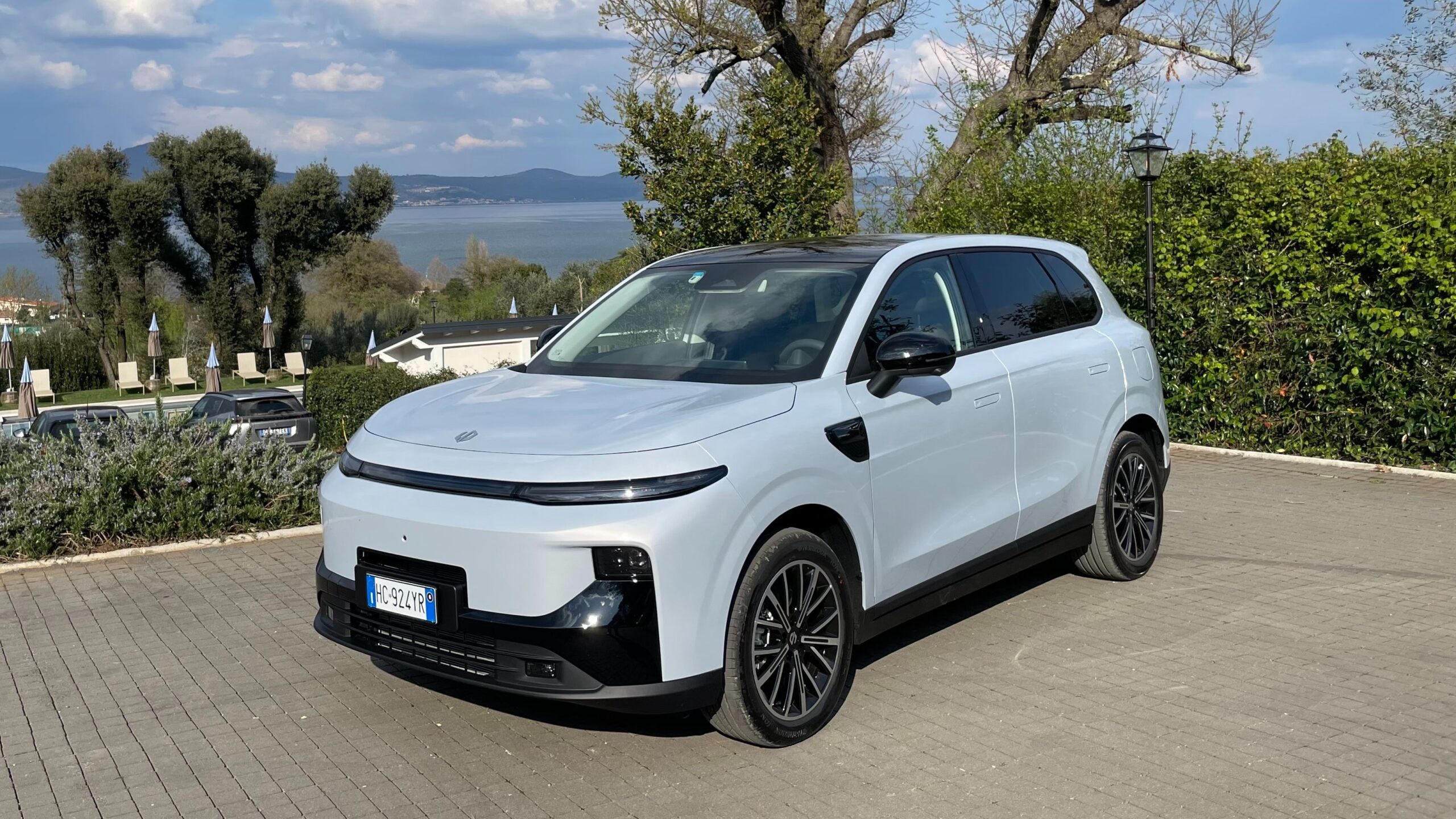 Modern electric SUV parked outdoors near scenic waterfront, showcasing clean design, sustainable mobility, and next-generation automotive innovation.