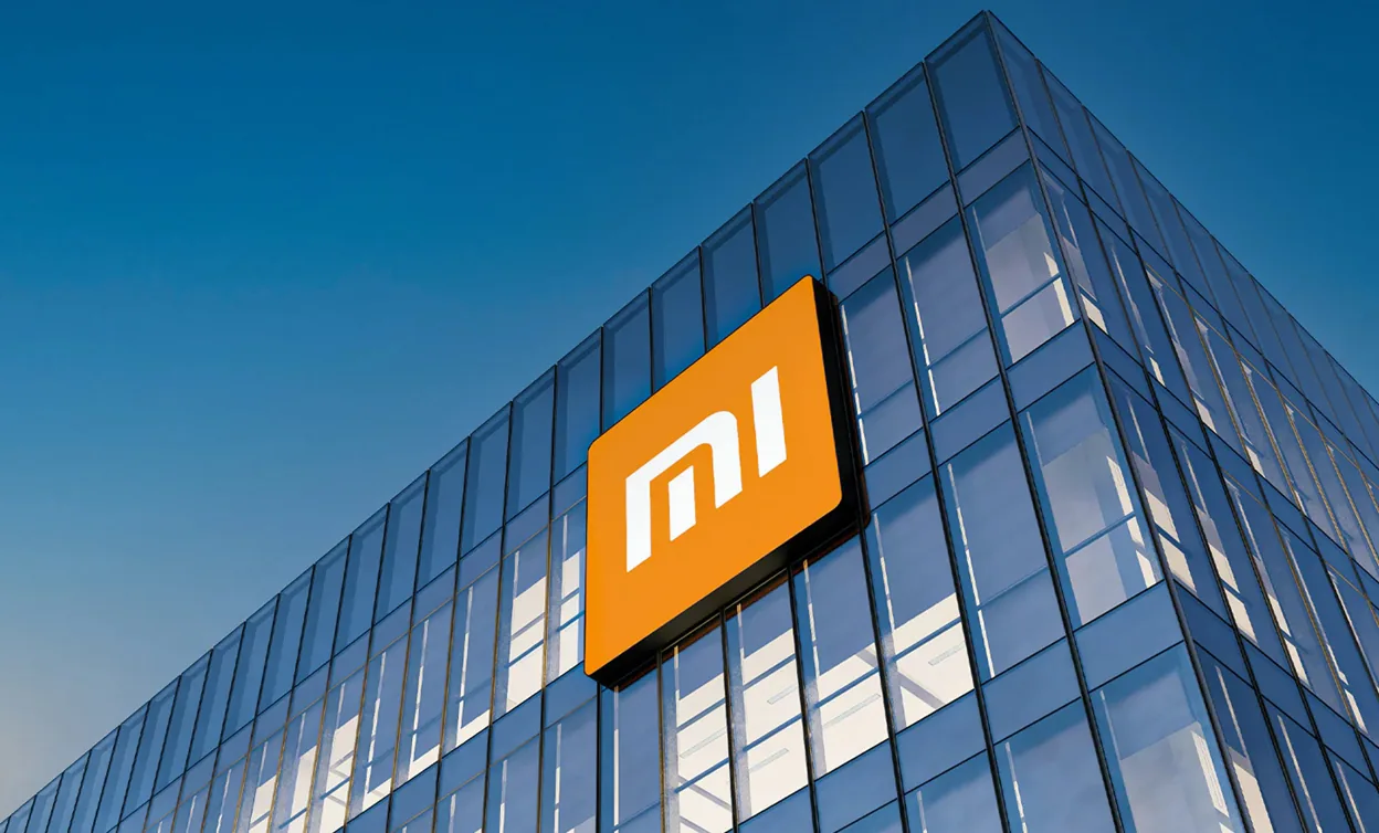 Xiaomi logo displayed on modern glass office building, representing Chinese consumer electronics brand and global tech company headquarters exterior.
