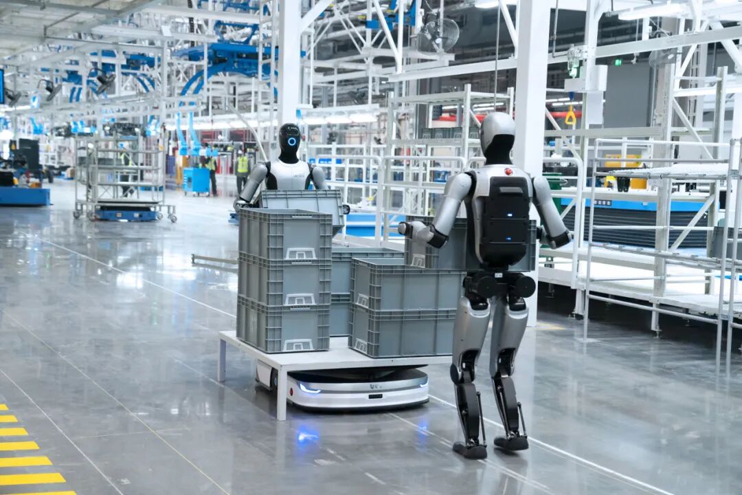 Humanoid robots operating inside an automated manufacturing facility, showcasing AI-driven industrial automation, robotics, and smart factory technology.