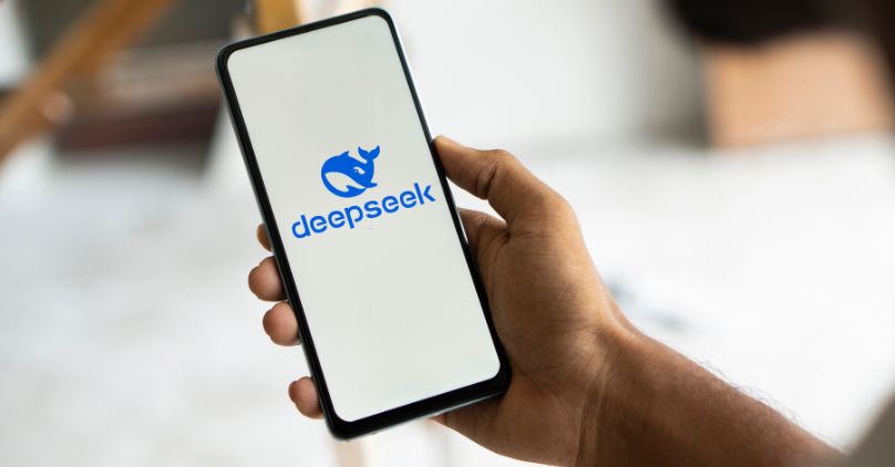 DeepSeek AI logo displayed on a smartphone screen with company branding in the background, representing China’s emerging artificial intelligence technology platform.
