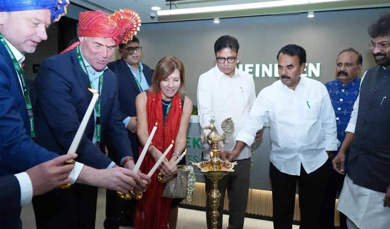 Business leaders and officials lighting ceremonial lamp at corporate event in India, symbolizing partnership, investment collaboration, and formal inauguration ceremony.