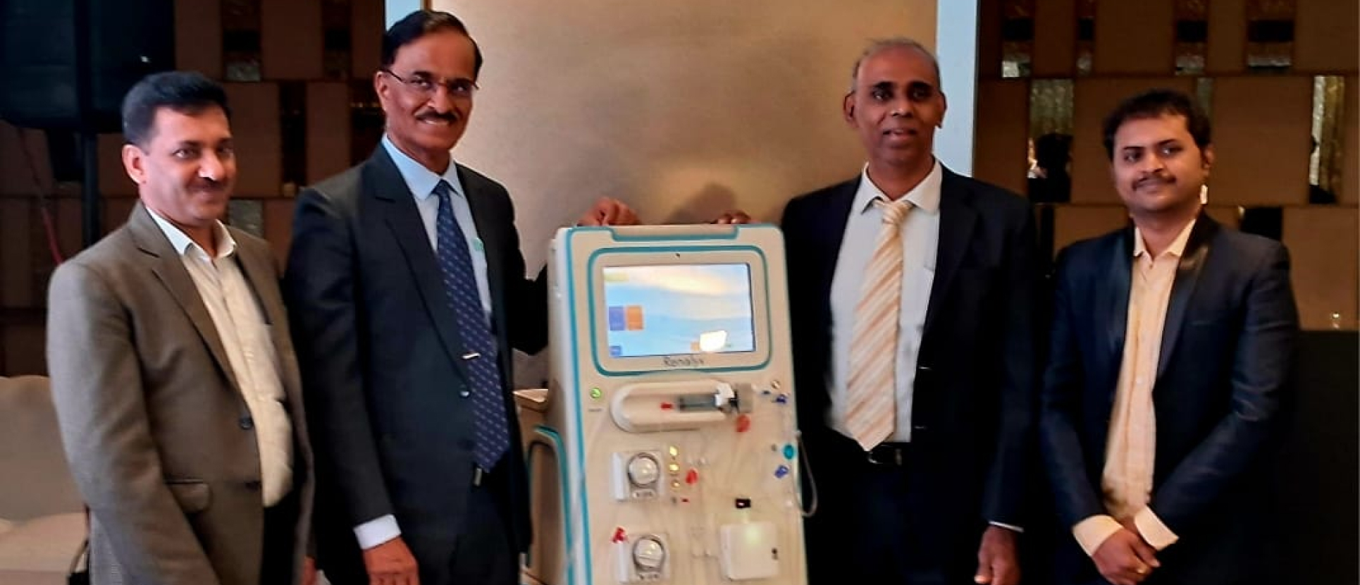Executives and healthcare professionals standing beside an advanced dialysis machine during a medical technology presentation, highlighting innovation in healthcare equipment and India’s growing medtech sector.