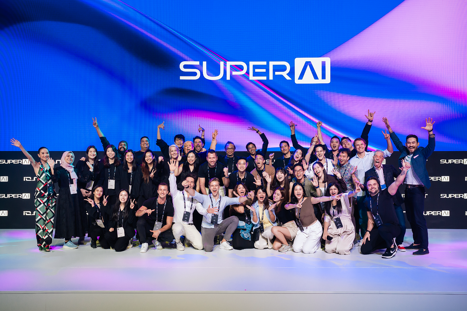 Global team members and attendees posing on stage at a SuperAI conference event, celebrating innovation and collaboration in artificial intelligence and emerging technology.