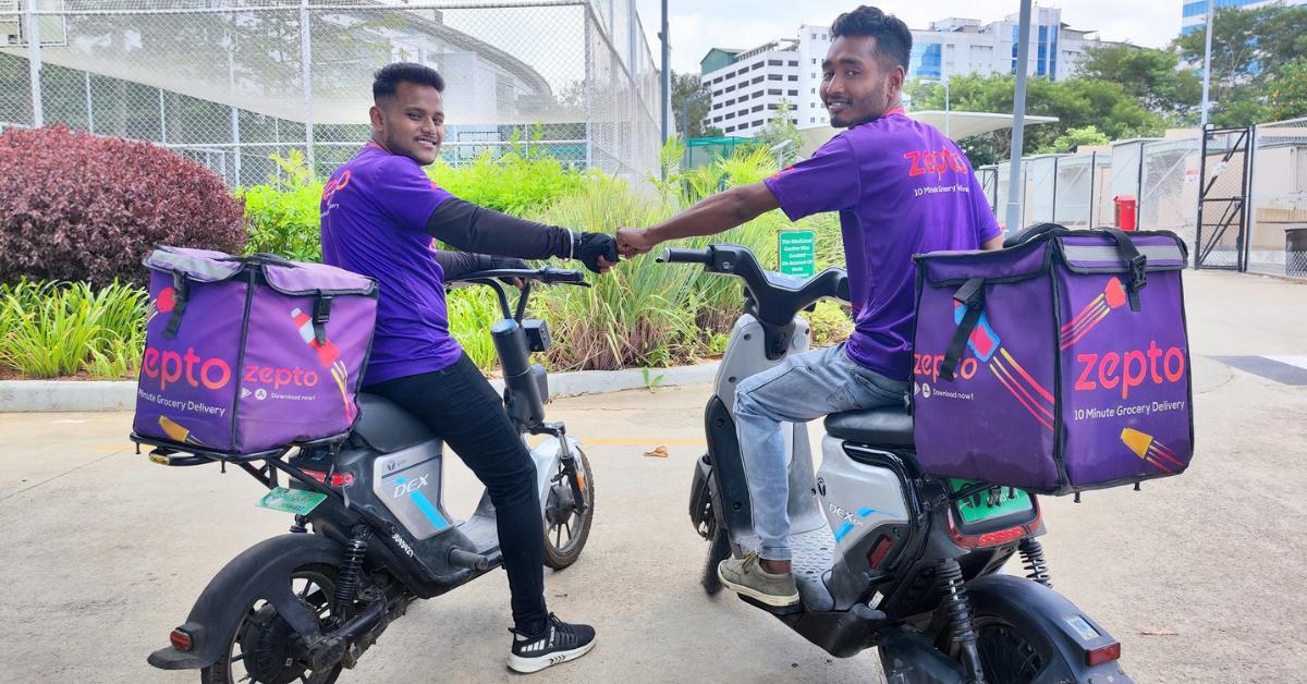 Zepto grocery delivery riders on electric scooters carrying branded delivery bags, representing India’s rapid quick-commerce and last-mile delivery ecosystem.